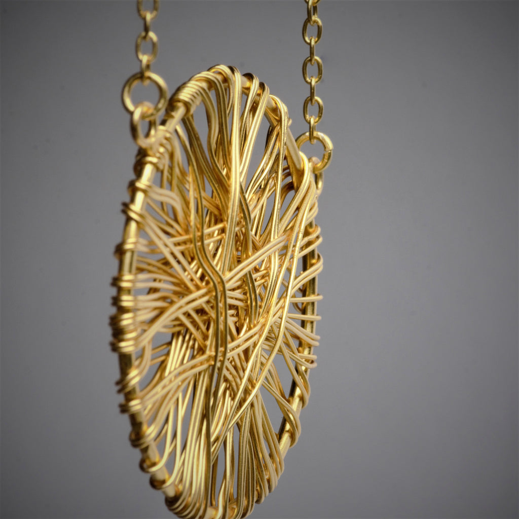 A mysterious yet subtle, dome-shaped lightweight pendant with metal wires wrapped around it. The pendant is 1 3/4 Inch in diameter and held firmly on a 19-inch long necklace.