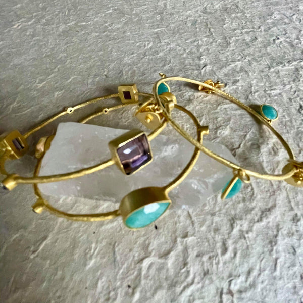 Elegant, fun, and flirtatious with its jingling soft sound, this stack is all you need as your statement piece. The set has 6 amazonites and 3 amethyst gemstones.  Pear-shaped amazonite is 9x13 in size and weighs 10.79 gms. Oval-shaped amazonite, on the other hand, is 9.78 gms in weight and the stunning square amethyst is 9.33 gms, with a total of 35.847 gms. in total.  The set is to the large side. It is 3 inches in diameter or 8 1/2 cms or 10 inches in circumference.