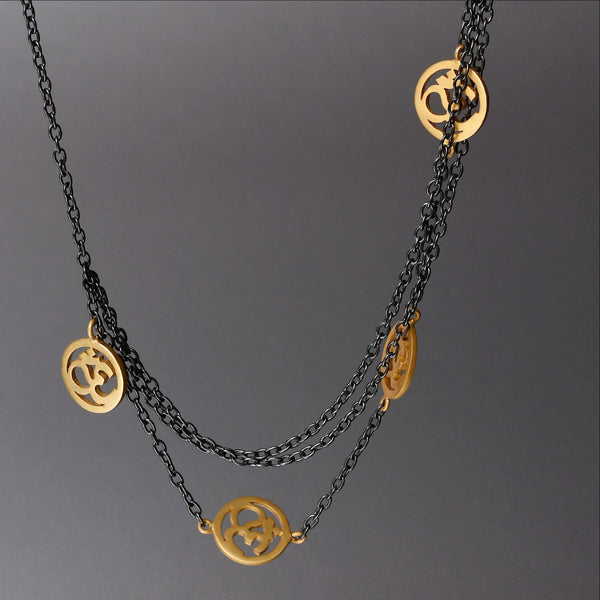 A spiritually inclined design where one side of the necklace holds cute little, gold plated 'OM' charms and on the other side are 3 plain chains. The necklace then holds yet another sleek, handcrafted 'OM' charm as a pendant. The necklace is a sterling silver base with black rhodium plating.