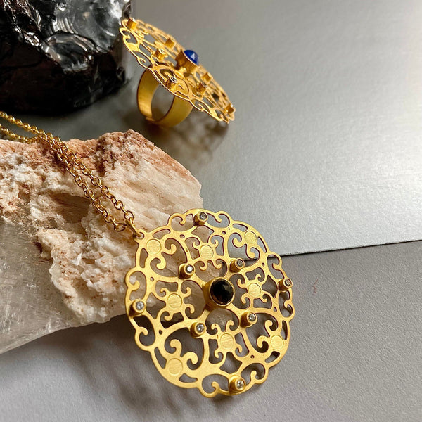 A no-weight, 17-inch long, gold plated-on brass Goddess flower necklace with a 1.38 cts of smoky quartz gemstone in the middle is simply too adorable. This a perfect example of minimalist jewelry that leaves quite a bold and lasting impression.  Cubic Zirconia adds that perfect bling you may be looking for. Lightweight, hand-hammered, and detailed oriented, this necklace signifies supremacy at its best.