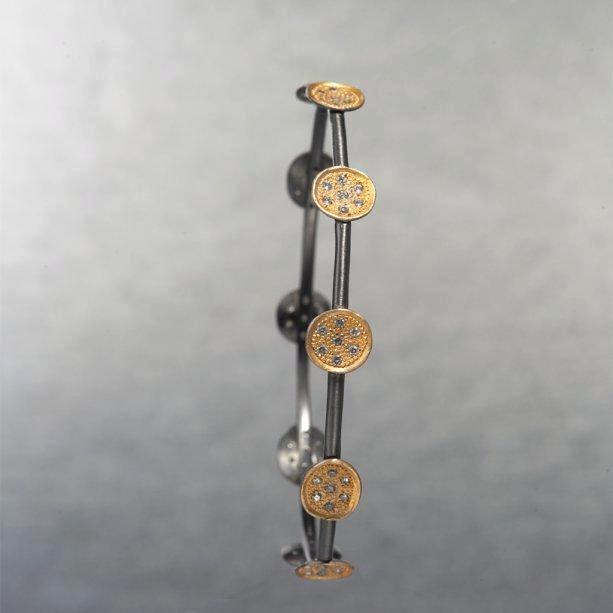 A dainty, delicate yet an appealing black rhodium plated, statement piece that creates a bold and beautiful first impression.The round gold plates on the bracelet, beautifully portray a blend of tiny cubic zirconia's thereby showcasing the mysterious shine.