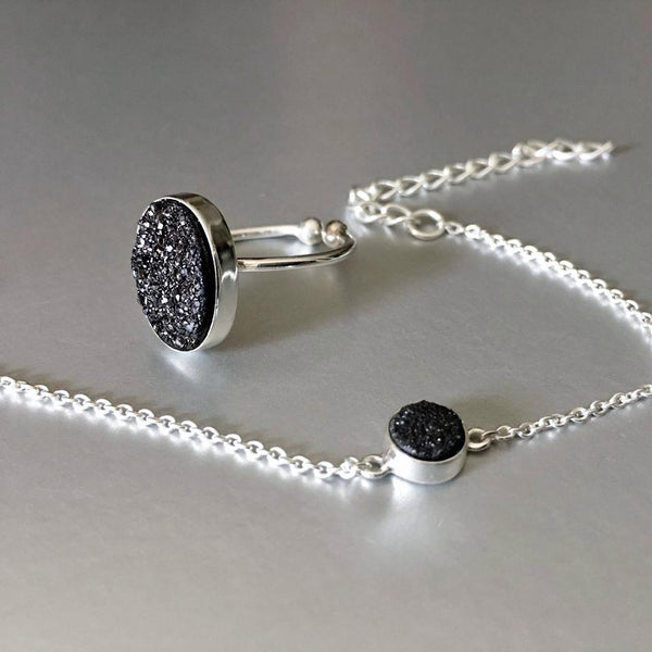 An adjustable, dainty, lightweight, sterling silver bracelet with stunning sparkling black druzy adds an artful addition to your everyday look. Druzy quartz is a stone material that is relatively inexpensive and beautiful when used in jewelry. It is a popular choice because of its sparkle and color and can readily be cut into interesting and unusual shapes.