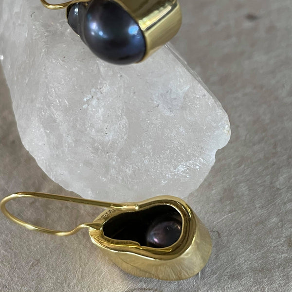 What a stunning piece of jewelry! These exquisite purplish greyish baroque pearl earrings in .925 sterling silver with gold plating, weighing 29.62 ct. are elegantly framed and must admit, are pieces of art. These drop earrings are 1 1/2 inches in length and 1/2 an inch in width. The total weight of the earrings is 8.133 gms.