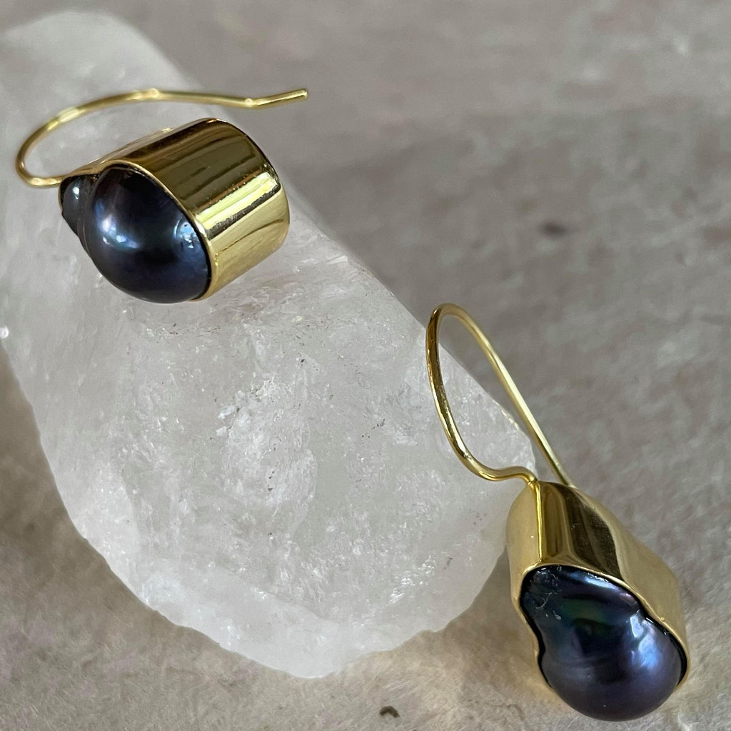What a stunning piece of jewelry! These exquisite purplish greyish baroque pearl earrings in .925 sterling silver with gold plating, weighing 29.62 ct. are elegantly framed and must admit, are pieces of art. These drop earrings are 1 1/2 inches in length and 1/2 an inch in width. The total weight of the earrings is 8.133 gms.