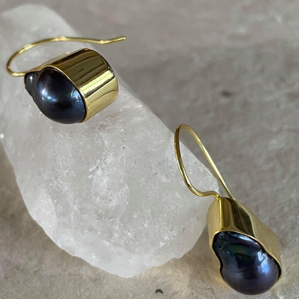 What a stunning piece of jewelry! These exquisite purplish greyish baroque pearl earrings in .925 sterling silver with gold plating, weighing 29.62 ct. are elegantly framed and must admit, are pieces of art. These drop earrings are 1 1/2 inches in length and 1/2 an inch in width. The total weight of the earrings is 8.133 gms.