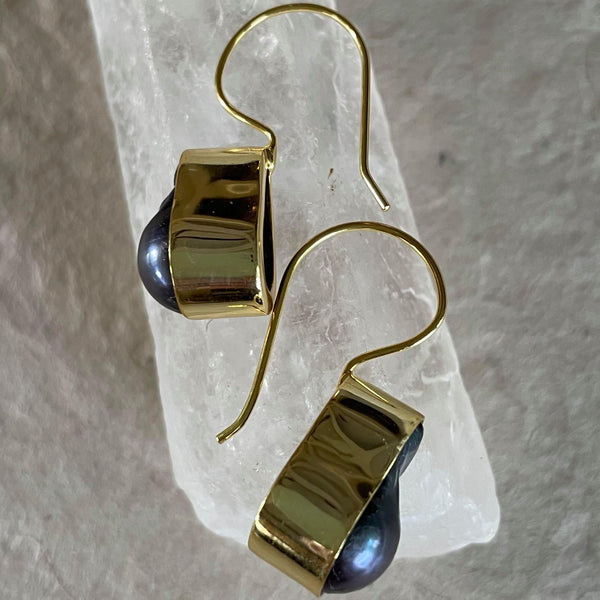 What a stunning piece of jewelry! These exquisite purplish greyish baroque pearl earrings in .925 sterling silver with gold plating, weighing 29.62 ct. are elegantly framed and must admit, are pieces of art. These drop earrings are 1 1/2 inches in length and 1/2 an inch in width. The total weight of the earrings is 8.133 gms.