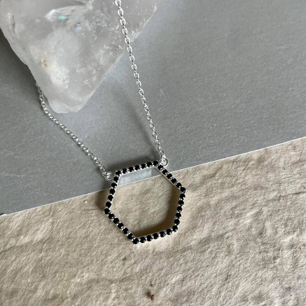 A Hexagon-shaped Amiya necklace, dainty, and delicate sterling silver necklace with a weight of 3.495 gms with adorable little black spinel gemstones with a weight of 0.7 ct. is your wear-anywhere accessory. It is 18 inches in length and has 3 adjustable rings to make your wear comfortable. The pendant is 20 mm by 22 mm in size.