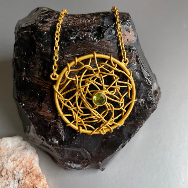 A lightweight 10-inch necklace with a woven medallion holds a beautiful .50 mm peridot gemstone graciously. An everyday trendy necklace that can be transported anytime to match formal attire with ease. As you must know, jewelry trends can change over time, but the gold necklace is always a stylish staple for both men and women. And, this Joelle necklace is no exception.