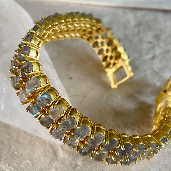 Carefully placed 2 rows of 6x4 mm, oval-shaped labradorite gemstones on a background of sterling silver base and 18kt. gold plating provides the perfect amount of sparkle and luxury to this Amara bracelet. The bracelet is 7 inches in length and 1/2 inch in width.