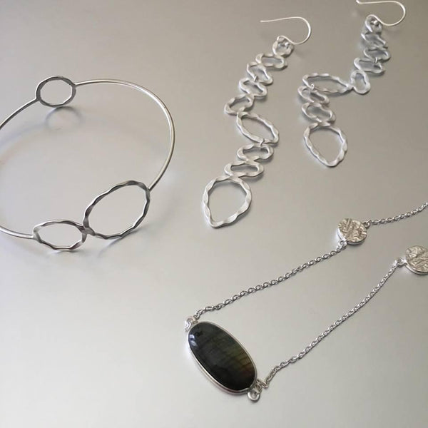 Dainty as can be, this flimsy yet durable sterling silver chain necklace with an adorable designed charm on each side and a glistening, striking labradorite pendant.