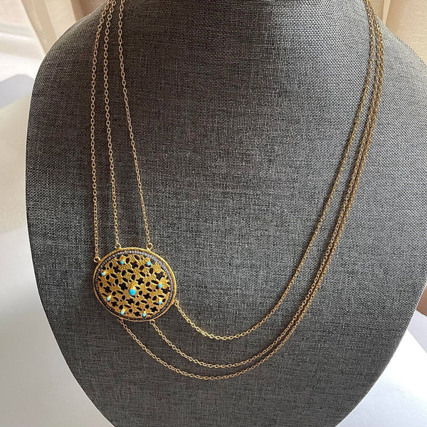 A triple-layered, elaborate 31.29 gms in weight, this necklace with a chunky yet lightweight 2-inch circumference medallion on one side, is enhanced with 9 embedded turquoises and numerous cubic zirconia.  This necklace is quite 'the' conversation starter.