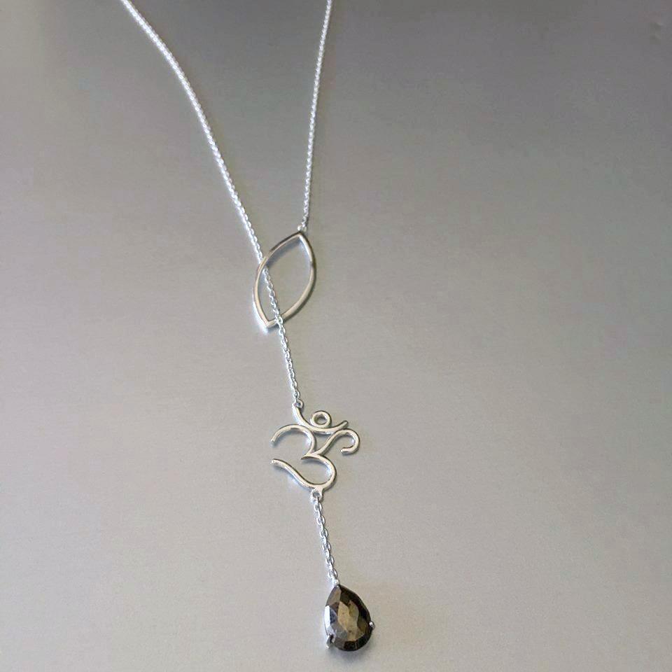 The most unusual design from the new collection: The lariat necklace. What better choice of pendant and charm than an "OM" with a smoky quartz gemstone. The delicate sterling silver chain goes through gracefully via the petal thereby exuding elegance and perfection of the OM