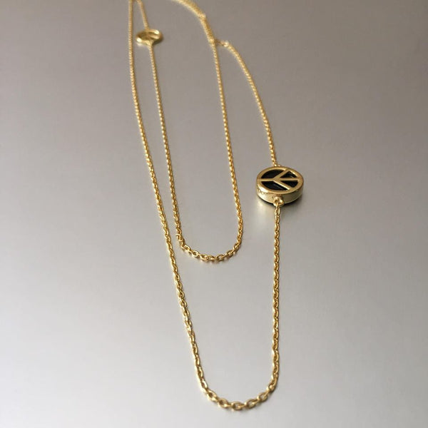 Double, gold plated chain necklace, one longer than the other hold a plain peace sign on one chain and a chunkier one with black onyx on the longer chain.