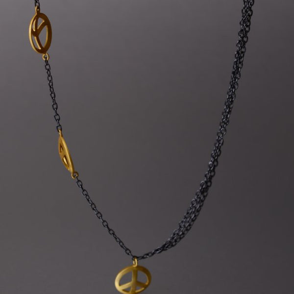 A mesmerizingly beautiful, sterling silver with rhodium plating on the chains and gold plating on the 'peace' charm is extraordinarily unique that exudes a meaningful, spiritual theme!   Do note: Only one side of the necklace holds cute little, gold-plated peace charms, and the other side holds 3 plain chains, thereby creating a playful, free-spirited, luxe boho appeal. Furthermore, the necklace then holds another charm as a penda