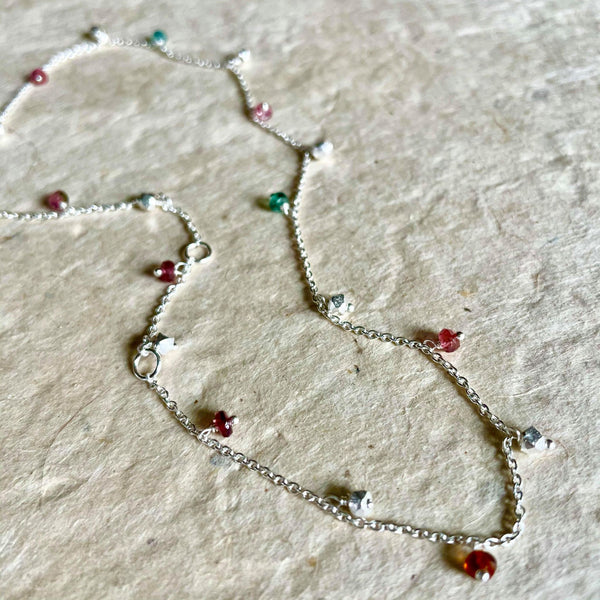 A delicate, 25 inches sterling silver necklace highlighting round-shaped multi-tourmaline gemstone with a weight of 4.38 ct. is rare to Mia Siya. The necklace highlights 4 adjustable rings so it can be worn as a choker making it a Y-necklace or 3 other varied lengths. A versatile piece of jewelry that can be transitioned from an 'everyday jewelry ' to an 'evening wear accessory,' The total weight of the necklace is 6.45 gms.