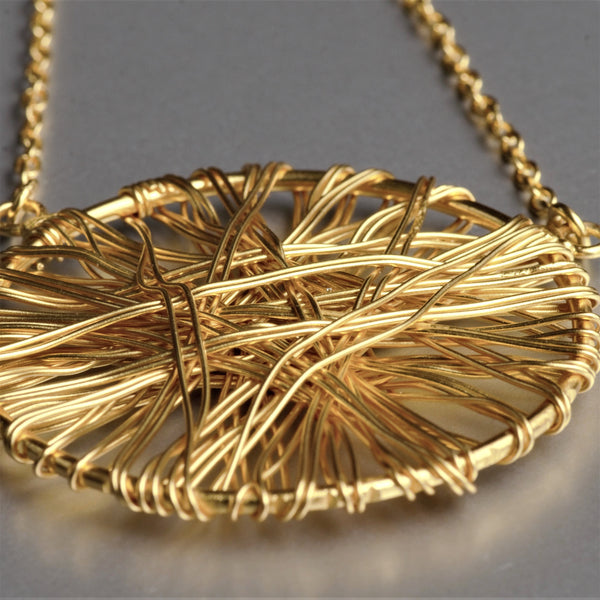 A mysterious yet subtle, dome-shaped lightweight pendant with metal wires wrapped around it. The pendant is 1 3/4 Inch in diameter and held firmly on a 19-inch long necklace.