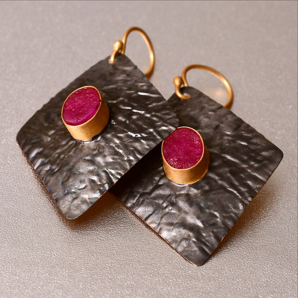 Captivating, lightweight earrings with a hand hammered texture is loved for its versatality. Dress up or dress down. The earrings are 4.5 cm long and 3 cm wide. It has a 1 cm dyed ruby with a druzy effect which is unique and eye-catching. 