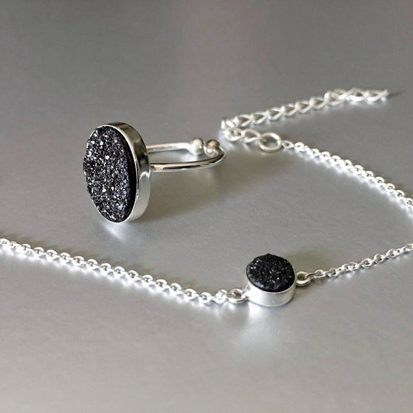  An adjustable, dainty, lightweight, sterling silver bracelet with stunning sparkling black druzy adds an artful addition to your everyday look. Druzy quartz is a stone material that is relatively inexpensive and beautiful when used in jewelry. It is a popular choice because of its sparkle and color and can readily be cut into interesting and unusual shapes.