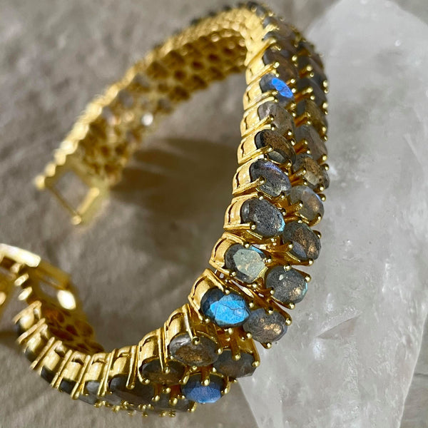 Carefully placed 2 rows of 6x4 mm, oval-shaped labradorite gemstones on a background of sterling silver base and 18kt. gold plating provides the perfect amount of sparkle and luxury to this Amara bracelet. The bracelet is 7 inches in length and 1/2 inch in width.