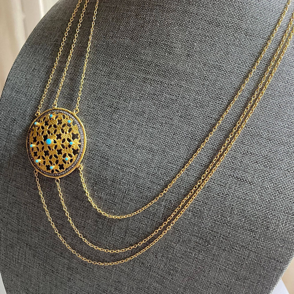 A triple-layered, elaborate 31.29 gms in weight, this necklace with a chunky yet lightweight 2-inch circumference medallion on one side, is enhanced with 9 embedded turquoises and numerous cubic zirconia.  This necklace is quite 'the' conversation starter. 
